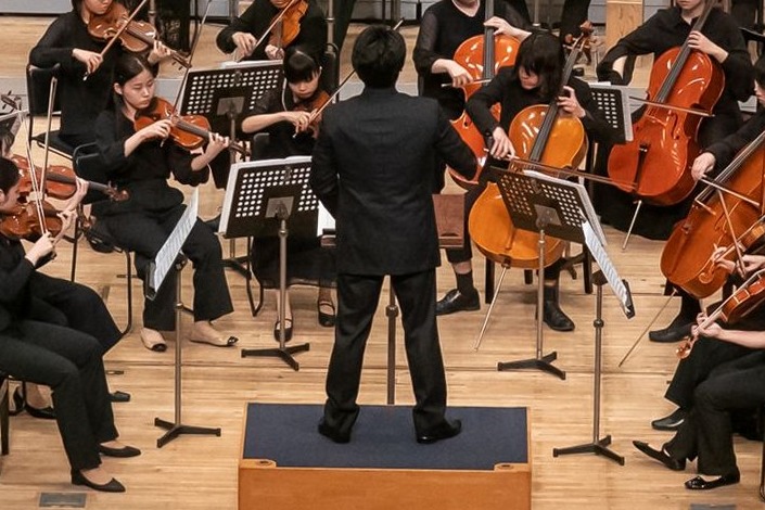 指揮台に立つ音楽監督とオーケストラ